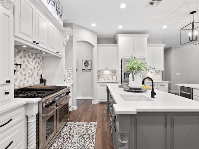 kitchen with light countertops, a sink, visible vents, and double oven range