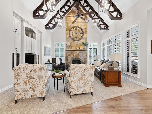 living room with high vaulted ceiling, a fireplace, ceiling fan, and wood finished floors