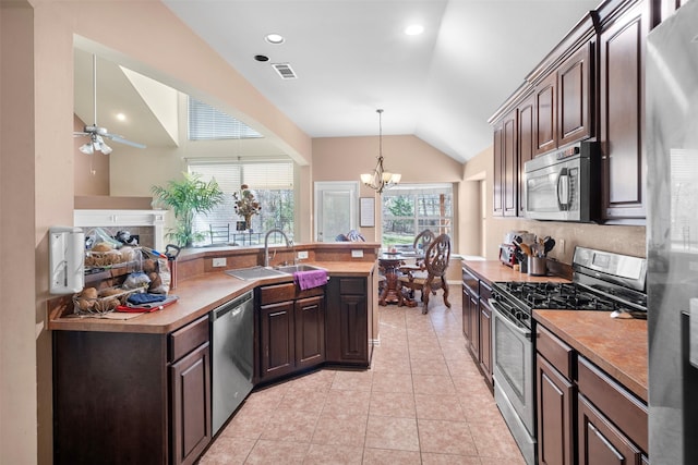 kitchen featuring light tile patterned flooring, a sink, visible vents, vaulted ceiling, and appliances with stainless steel finishes