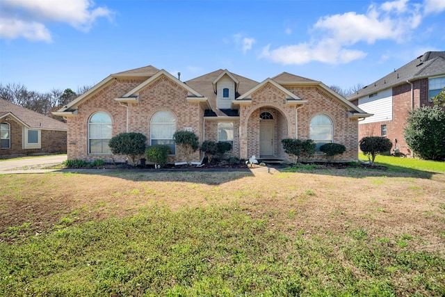 view of front of property with a front yard and brick siding