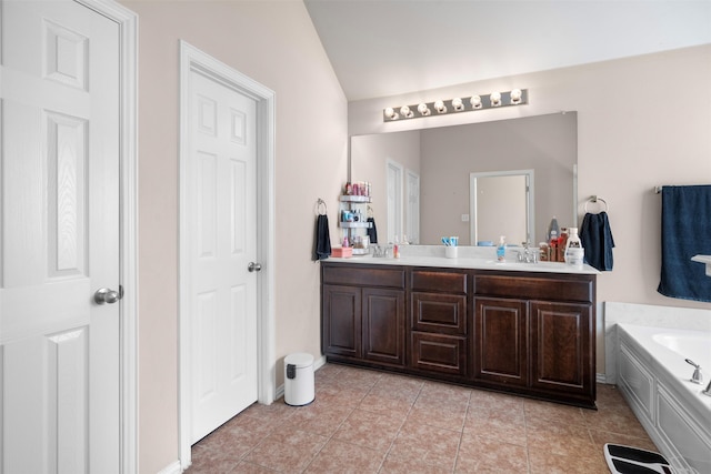 bathroom with double vanity, tile patterned flooring, a sink, and a bath