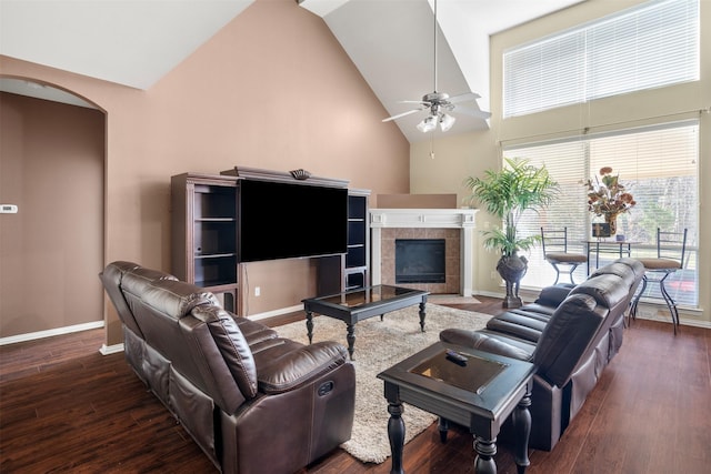 living room with arched walkways, high vaulted ceiling, wood finished floors, and baseboards