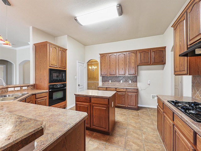 kitchen featuring arched walkways, a sink, decorative backsplash, black appliances, and decorative light fixtures