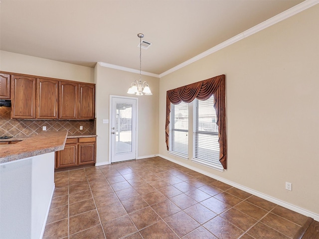 kitchen with visible vents, brown cabinets, light countertops, a chandelier, and backsplash