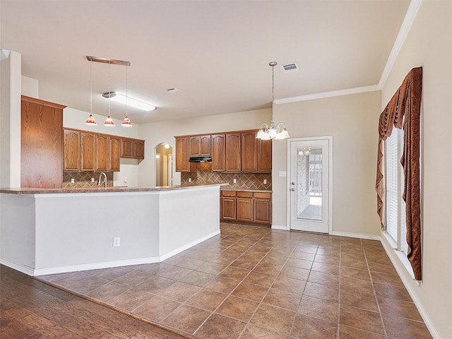 kitchen featuring brown cabinets, visible vents, and decorative light fixtures