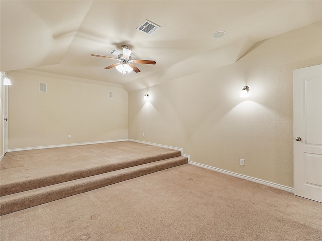 unfurnished room featuring ceiling fan, lofted ceiling, light carpet, visible vents, and baseboards