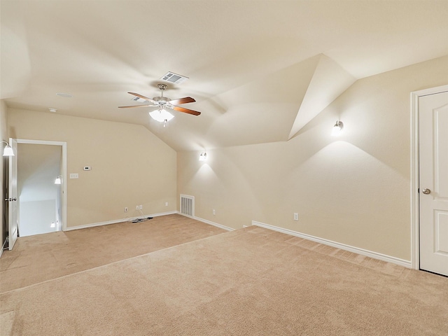 bonus room featuring lofted ceiling, a ceiling fan, visible vents, and light colored carpet