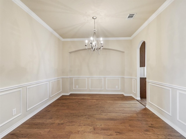 unfurnished room with ornamental molding, wood finished floors, visible vents, and a notable chandelier