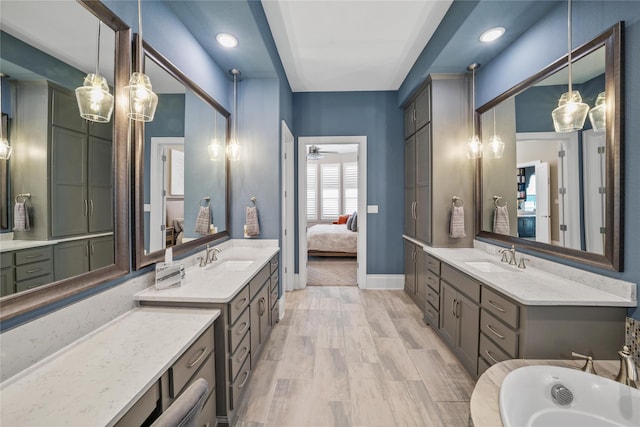 bathroom with a ceiling fan, two vanities, a sink, and ensuite bathroom