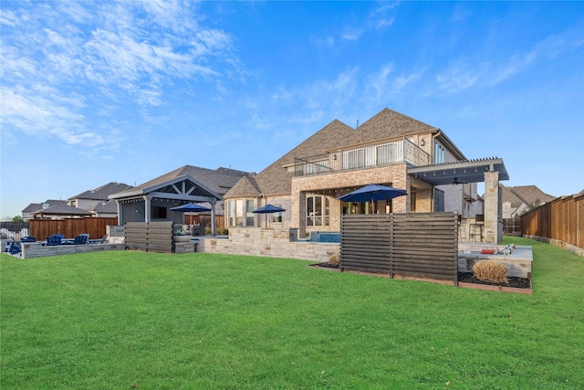 view of yard with a balcony, a patio area, and a fenced backyard