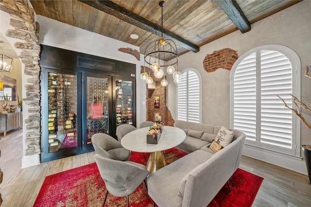 dining space featuring wooden ceiling, wood finished floors, beam ceiling, and a notable chandelier