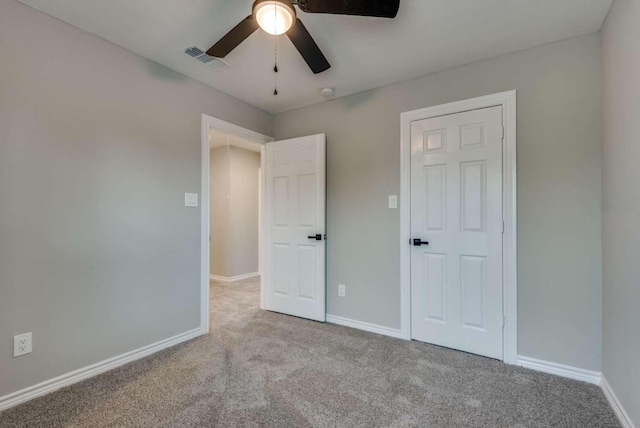 unfurnished bedroom with carpet floors, baseboards, and visible vents