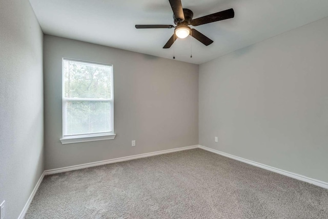 unfurnished room with a ceiling fan, carpet, and baseboards