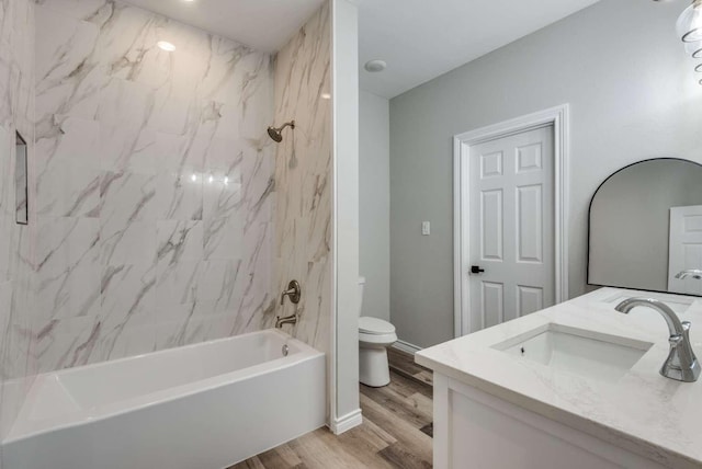 full bath featuring double vanity, toilet, tub / shower combination, a sink, and wood finished floors