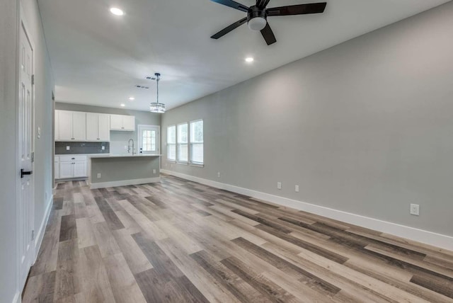 interior space featuring light wood-style floors, baseboards, and recessed lighting