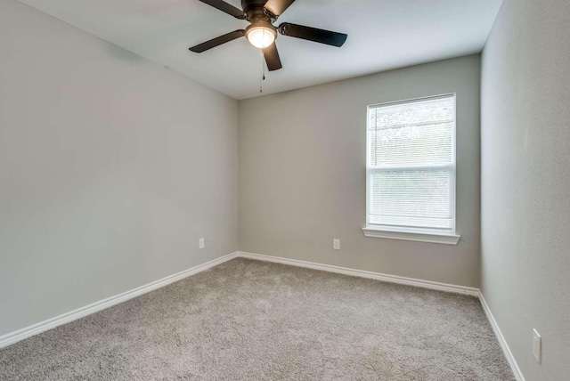 carpeted empty room with ceiling fan and baseboards