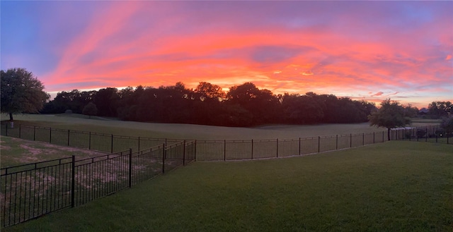 yard at dusk featuring fence