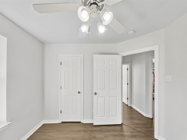 unfurnished bedroom featuring ceiling fan, wood finished floors, and baseboards