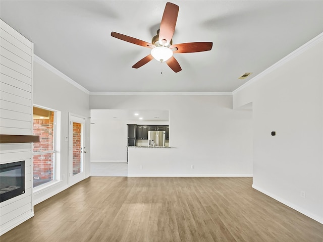 unfurnished living room featuring light wood-style flooring, visible vents, and crown molding