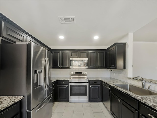 kitchen featuring stainless steel appliances, visible vents, a sink, and backsplash