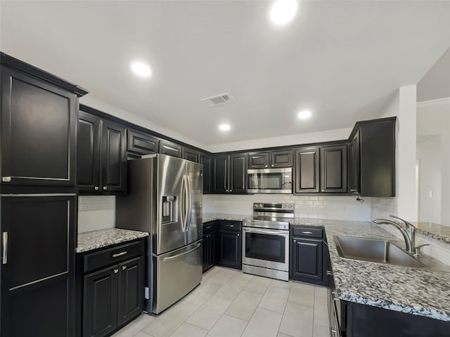 kitchen featuring tasteful backsplash, visible vents, stainless steel appliances, and a sink