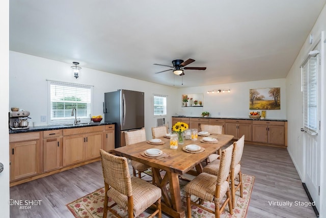 dining room with light wood-style floors and a ceiling fan