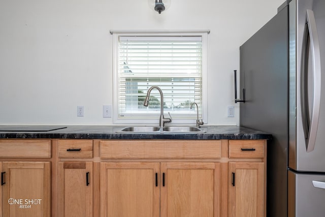 kitchen featuring black electric stovetop, a sink, and freestanding refrigerator