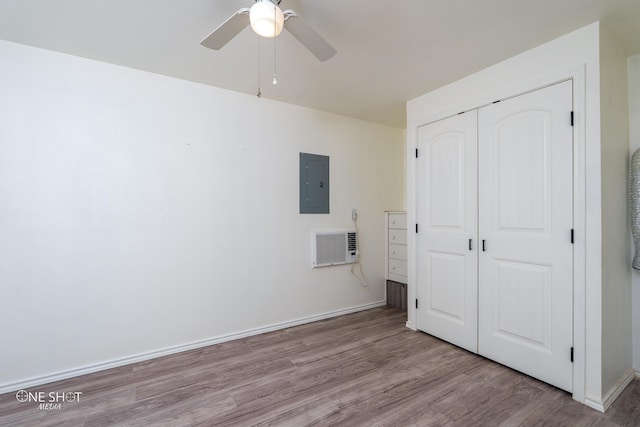 unfurnished bedroom featuring a closet, visible vents, wood finished floors, electric panel, and baseboards