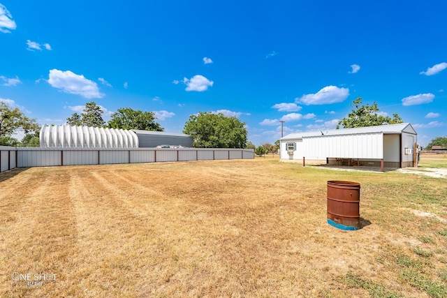 view of yard with an outbuilding and fence