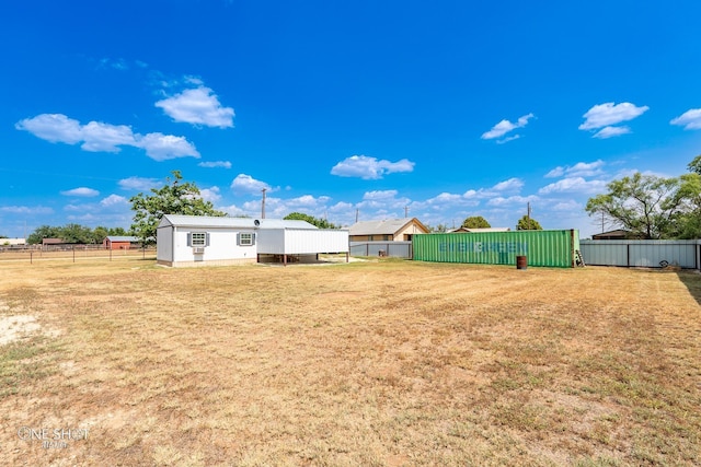 view of yard featuring fence and an outbuilding