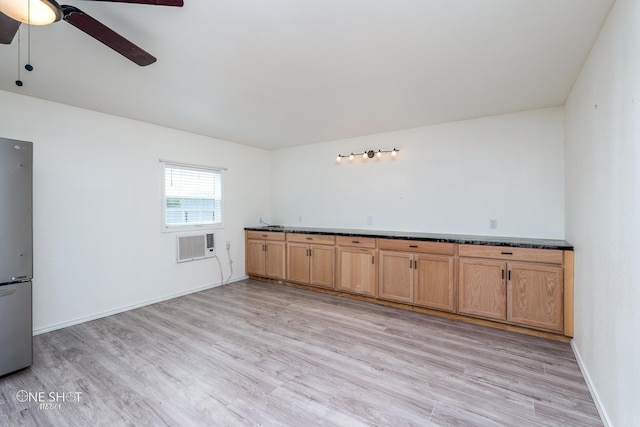 unfurnished room featuring ceiling fan, light wood finished floors, a wall mounted air conditioner, and baseboards