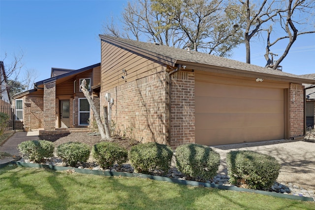 view of property exterior with an attached garage, driveway, and brick siding