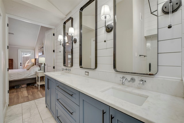 full bath with vaulted ceiling, marble finish floor, ensuite bath, and a sink