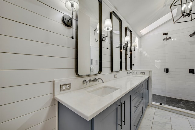 bathroom with vaulted ceiling, marble finish floor, a sink, and a tile shower