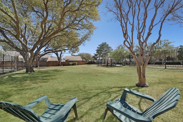 surrounding community with fence and a yard