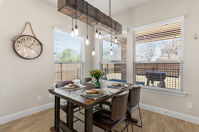 dining space featuring baseboards and wood finished floors