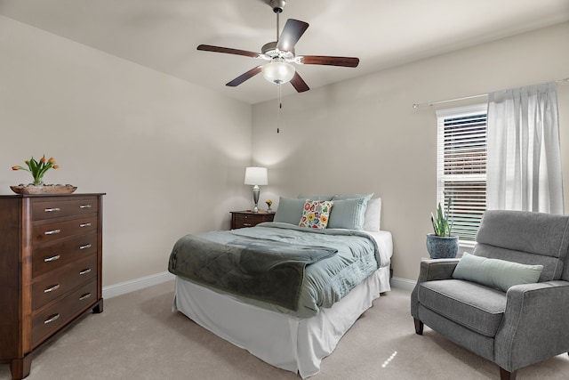 bedroom featuring light carpet, ceiling fan, and baseboards