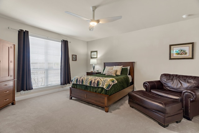 bedroom featuring a ceiling fan, light carpet, and baseboards