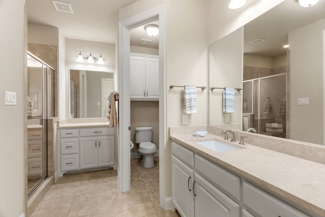 bathroom with tile patterned flooring, toilet, vanity, visible vents, and a shower stall