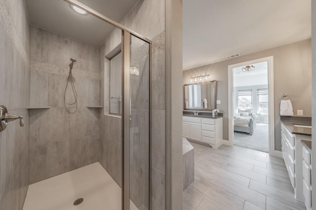 bathroom with visible vents, ensuite bathroom, a stall shower, vanity, and baseboards