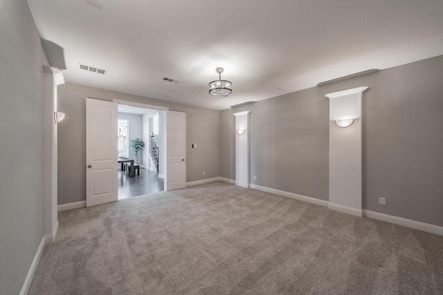 unfurnished room featuring carpet flooring, visible vents, and baseboards