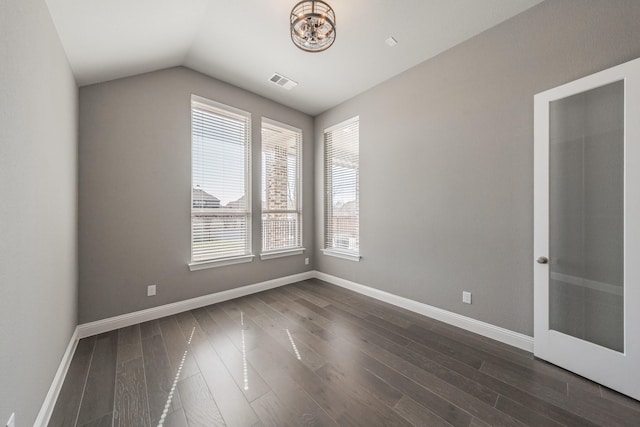 empty room with dark wood-type flooring, visible vents, vaulted ceiling, and baseboards