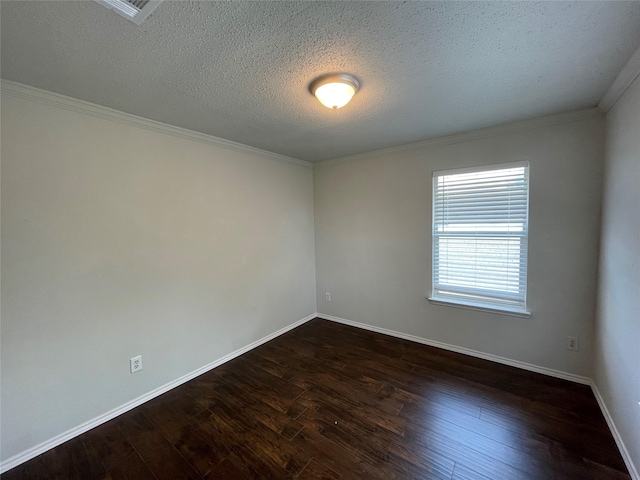 spare room with dark wood-style floors, ornamental molding, a textured ceiling, and baseboards