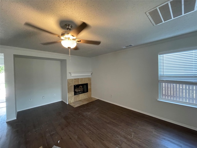 unfurnished living room featuring visible vents, ornamental molding, a tiled fireplace, and wood finished floors