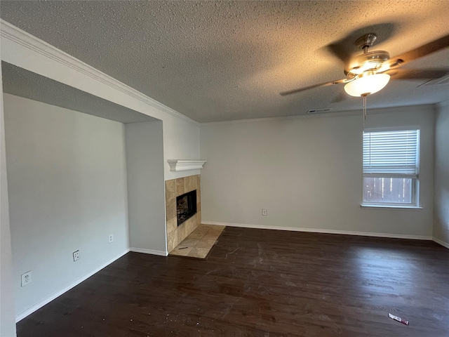 unfurnished living room featuring a textured ceiling, ceiling fan, wood finished floors, baseboards, and a tiled fireplace