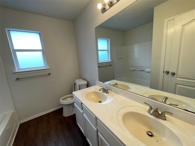 bathroom with a sink, toilet, and wood finished floors