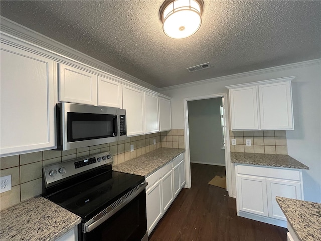 kitchen featuring appliances with stainless steel finishes, dark wood-style flooring, visible vents, and white cabinets