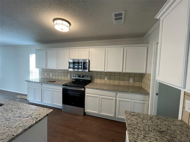 kitchen with visible vents, appliances with stainless steel finishes, white cabinets, and dark wood-type flooring