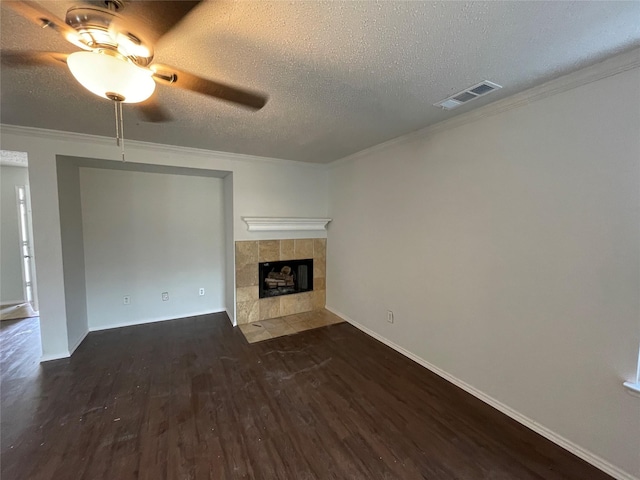 unfurnished living room featuring crown molding, a fireplace, visible vents, a textured ceiling, and wood finished floors