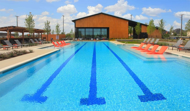 pool with a patio area and a pergola